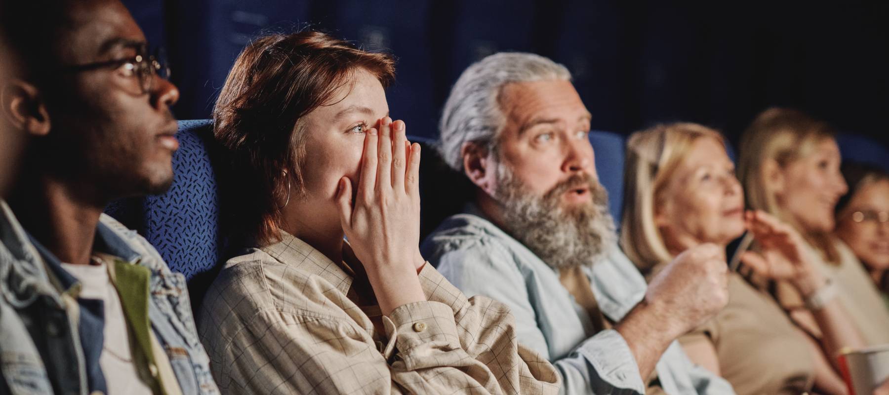 A group of people watch a scary movie.