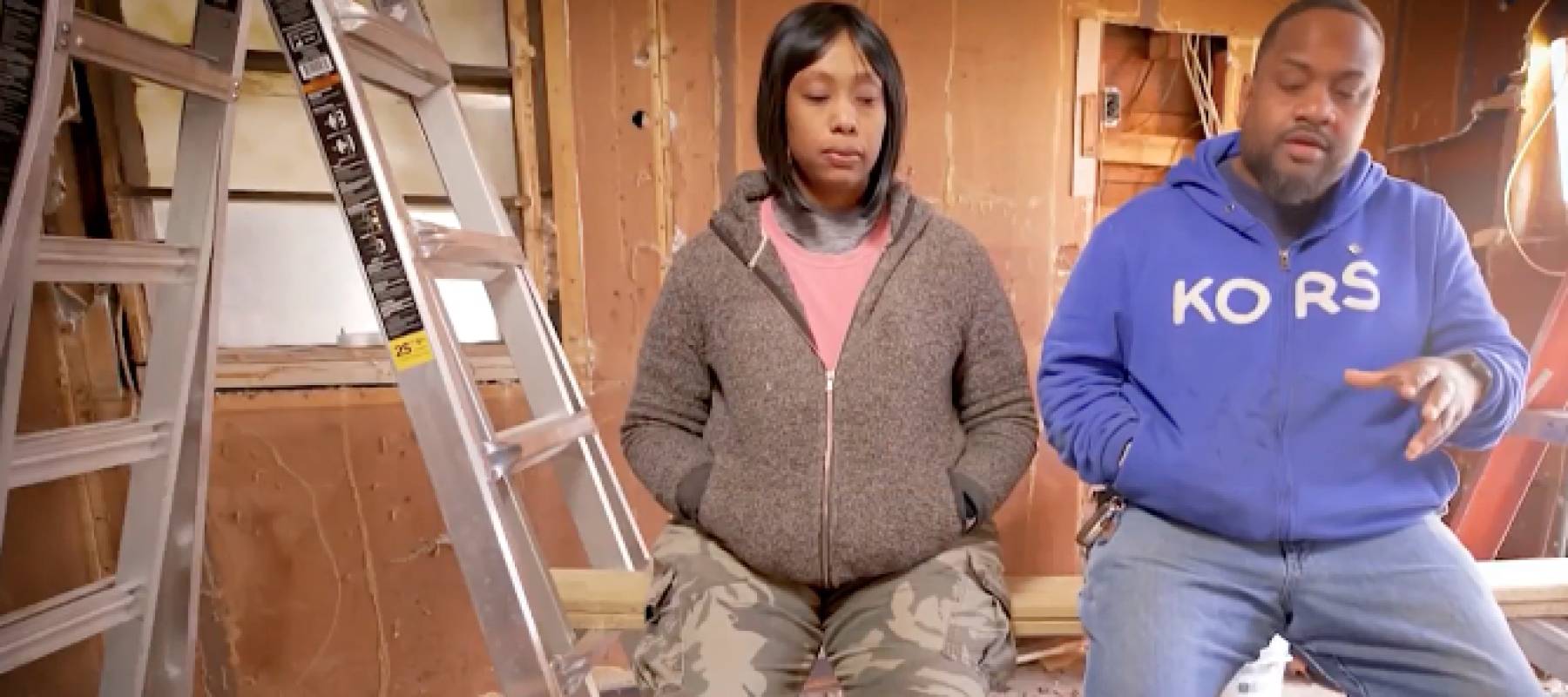 Couple talk on camera inside a house under construction.