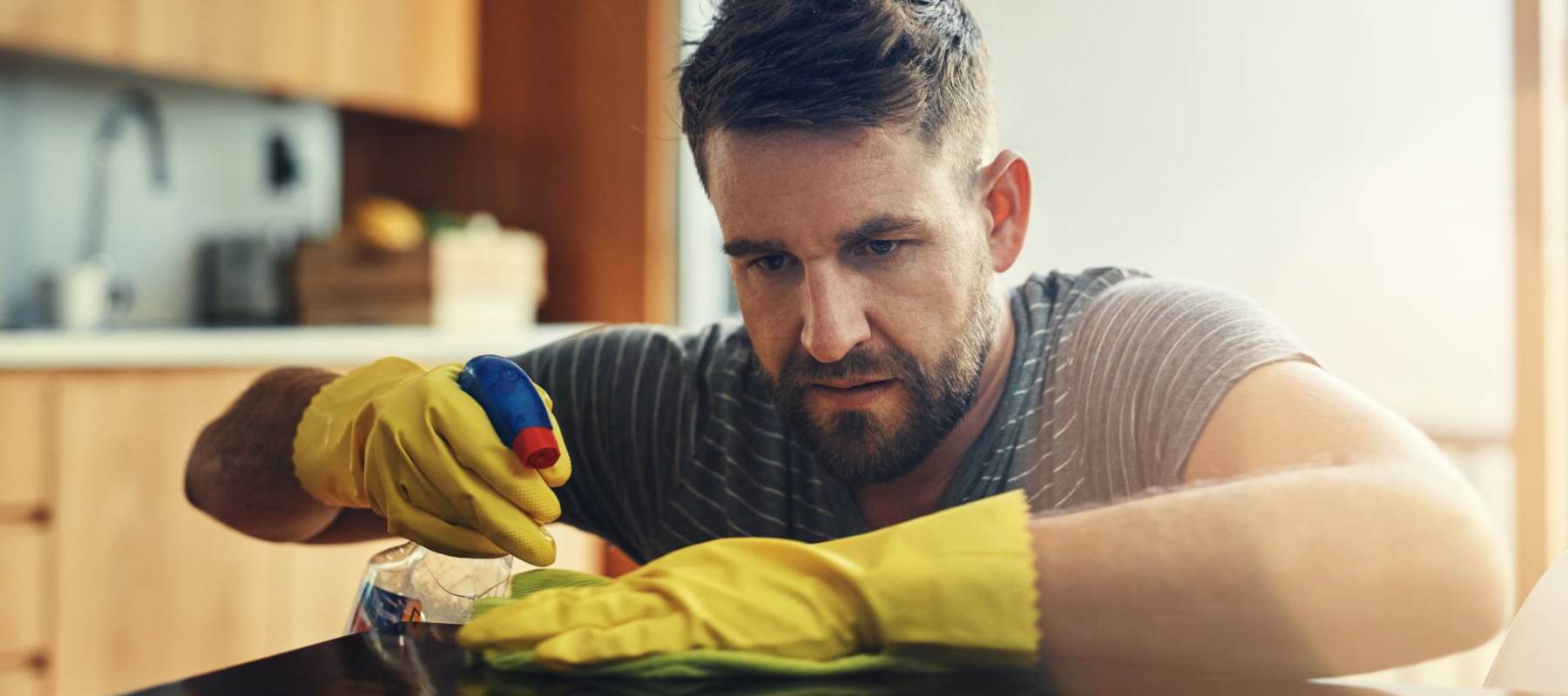 Middle-aged man cleaning kitchen counter
