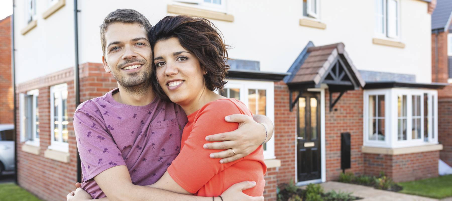 Couple in front of their new home.