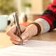 A closeup of a woman's hand signing a contract