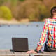 Man with laptop at lake