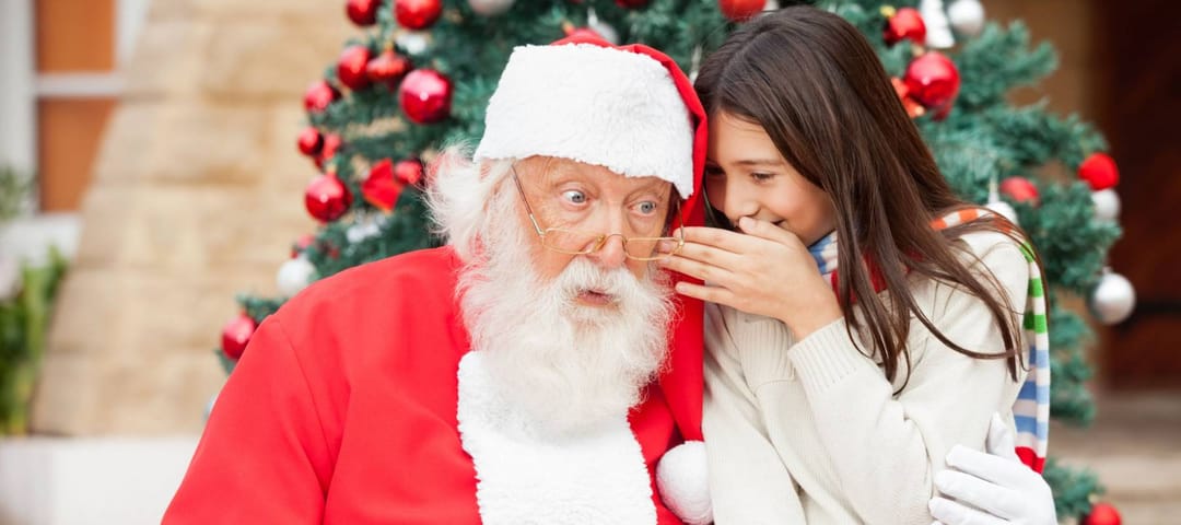 Shocked Santa Claus listening to girl's wish in front of Christmas tree