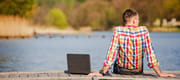 Man with laptop at lake