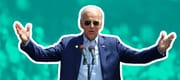 Joe Biden stands at a podium with aviator glasses on and his arms raised.