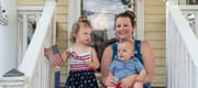Mom and kids on front porch of their home on Fourth of July