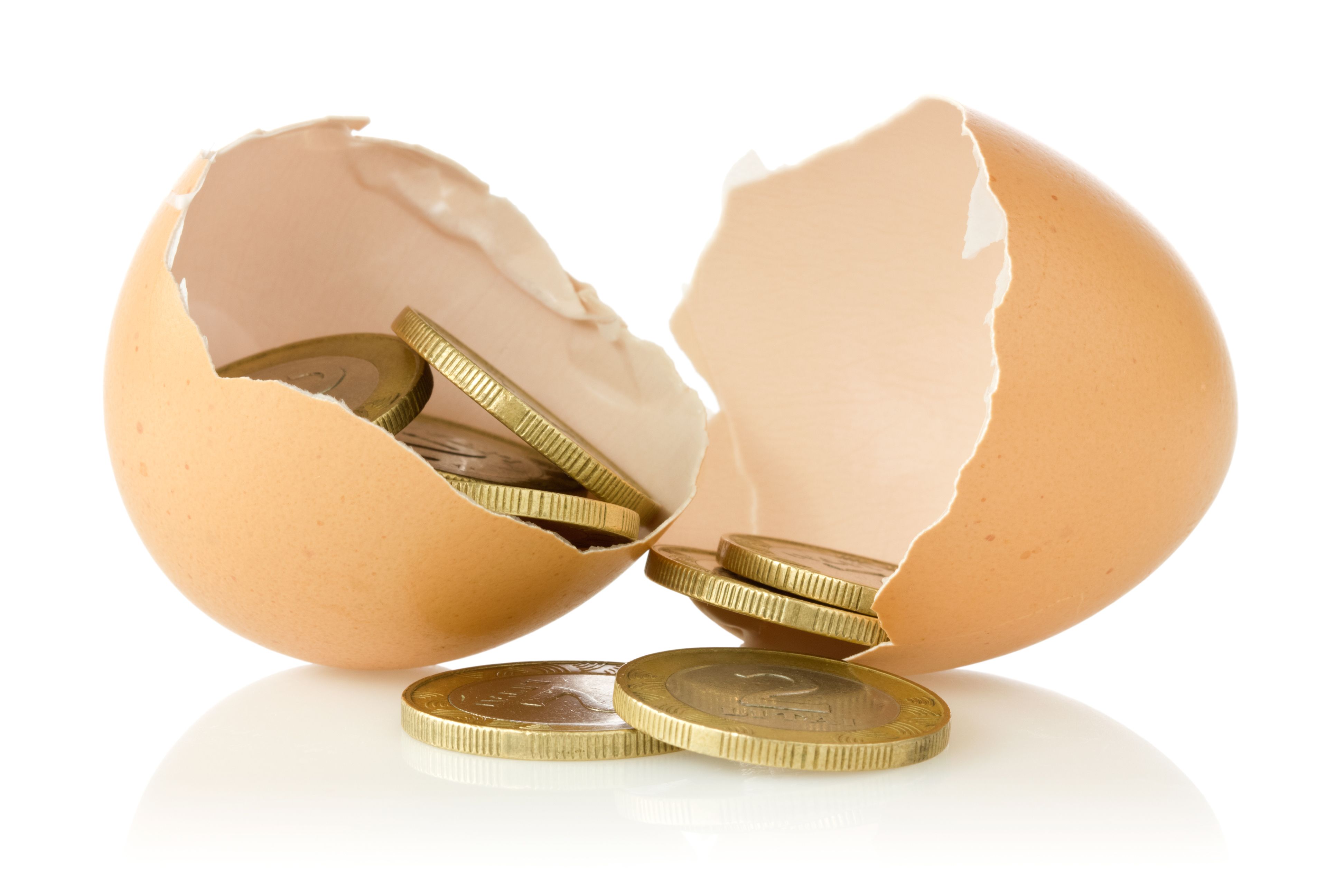 An egg broken open to reveal coins