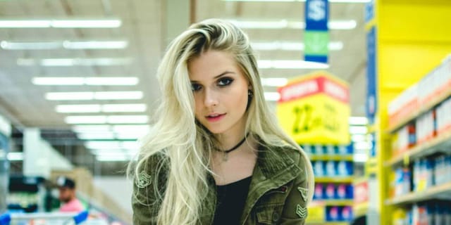 woman looks into camera while crouching on one knee in a shopping aisle