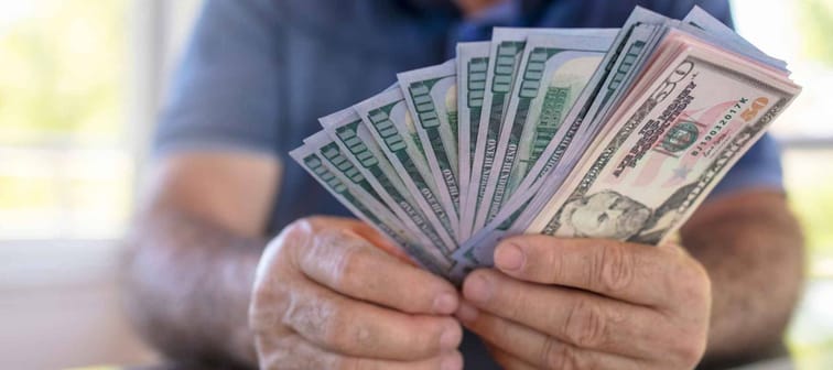 Mature man holding US dollars.