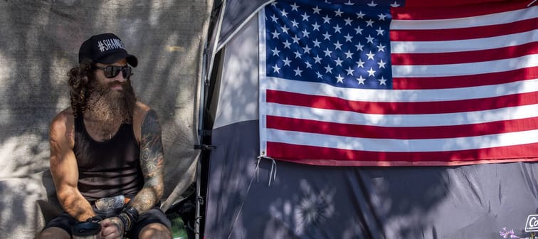Jonathan Garcia sits next to his tent in a homeless encampment outside the West L.A. Veterans Affairs campus in Los Angeles, Aug. 30, 2021.