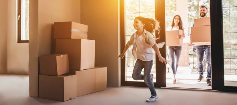 Happy family with cardboard boxes in new house at moving day.