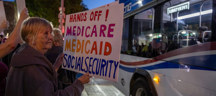 A woman holds a sign expressing fear of cuts to Medicare, Medicaid and Social Security