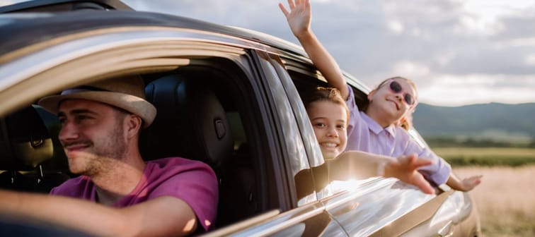 Happy family enjoying drive in their new car.