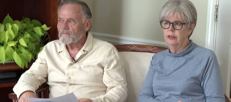 Man and woman sitting on a couch on camera.