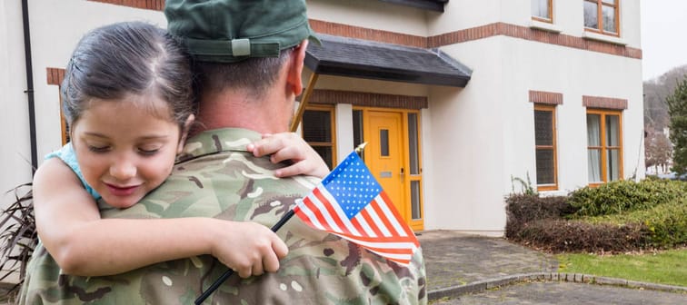 Composite images of American soldier carrying girl in front of a house