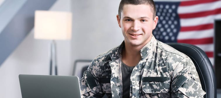 Soldier working with laptop in headquarters building