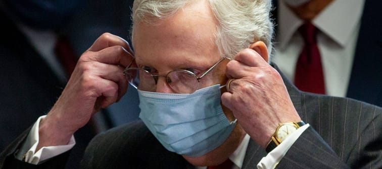 Senate Majority Leader Mitch McConnell takes off a face mask before a news conference in Washington, D.C., on May 5, 2020.