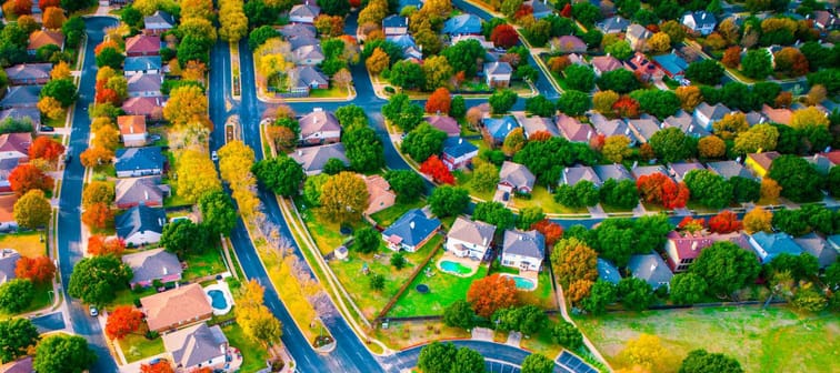 curved designs and layouts aerial drone view above Suburb neighborhood with fall colors charging leaves and gorgeous colorful landscape above houses and homes