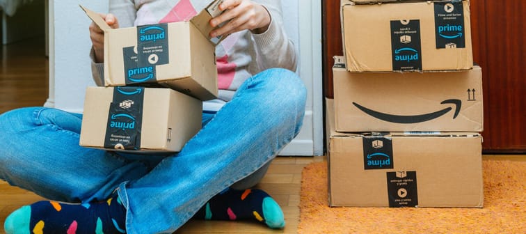 Woman sitting on ground opening Amazon packages