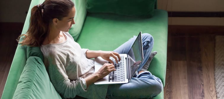Relaxed woman on couch browsing the Internet