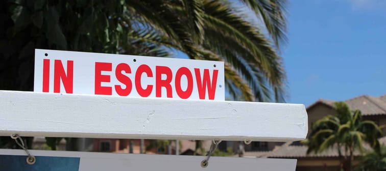 Close up of a sign "in Escrow" on a home for sale sign