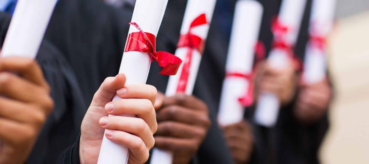 group of multiracial graduates holding diploma
