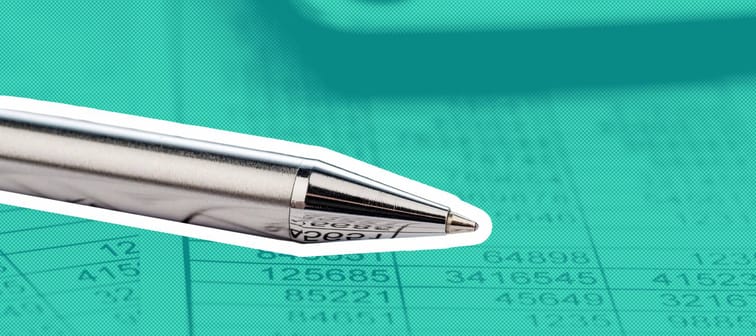 A calculator and pen on a balance sheet.