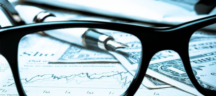financial chart near dollars seen by unfocused glasses