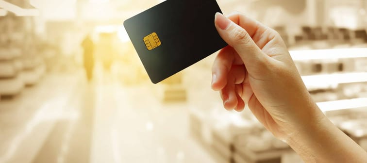 hand holding credit card with blur store background