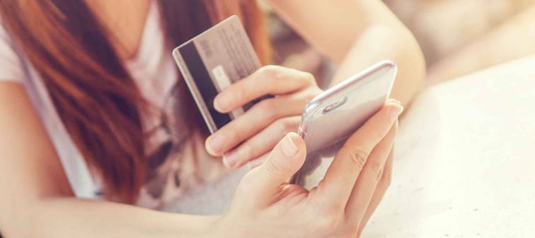 Close up of woman holding credit card and smartphone