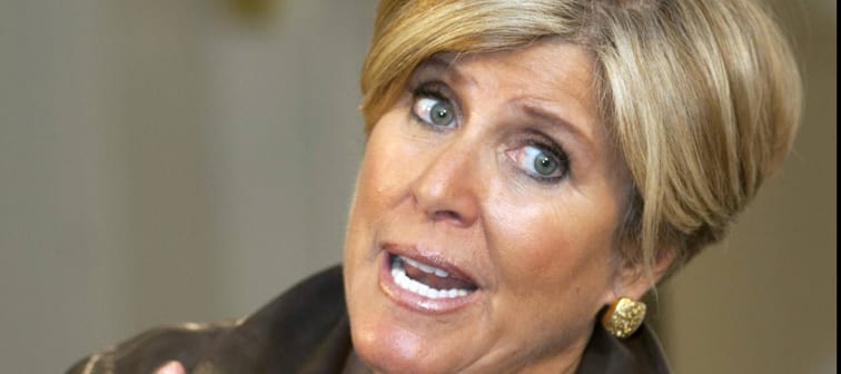Suze Orman speaks with head tilted and hands up