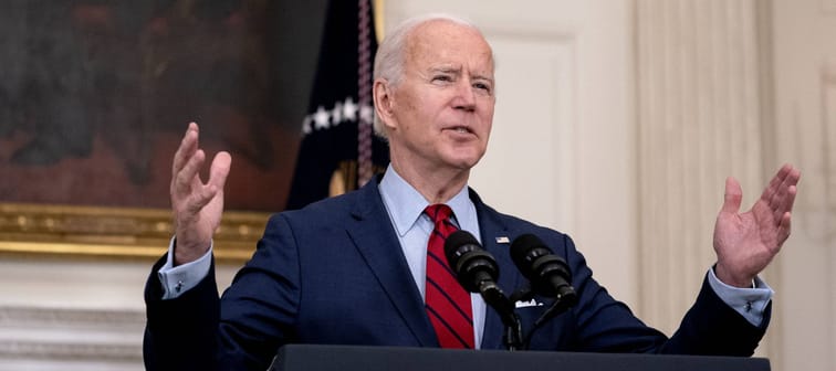 Joe Biden speaks at a podium with his hands up