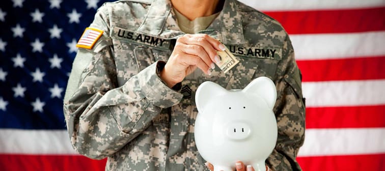 Soldier: Military Female Putting Money In Piggy Bank