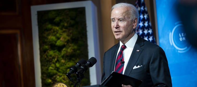 Joe Biden stands at a podium, looking off to the side of the camera with a worried look on his face