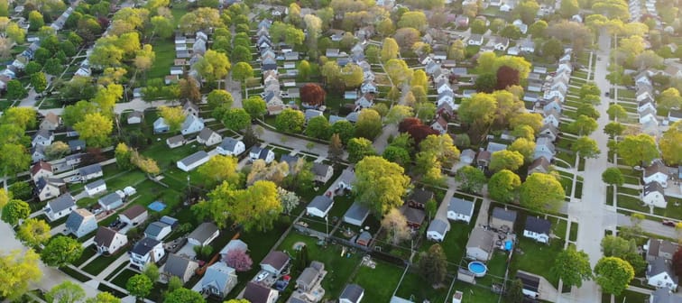 Aerial view of residential houses at spring (may). American neighborhood, suburb.  Real estate, drone shots, sunset, sunlight, from above.