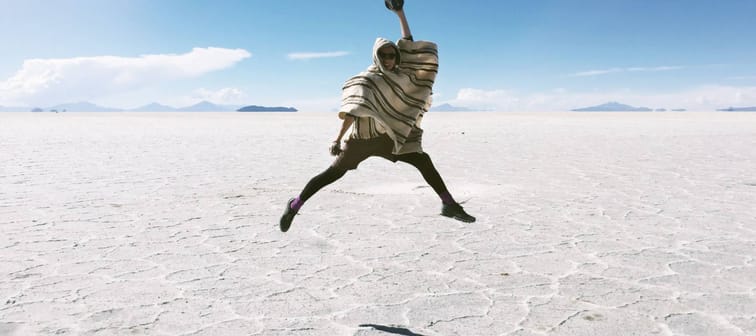 A man is jumping up on the dazzling Uyuni Salt Flat in Bolivia - the one of the travel destinations.