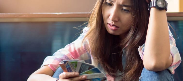 stressed young asian woman trying to find money to pay credit card debt.