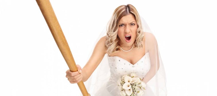 Angry young bride holding a baseball bat and yelling