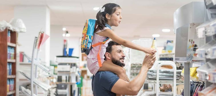Father and daughter buying school supplies preparing to go back to school, preparing for september, girl on shoulders