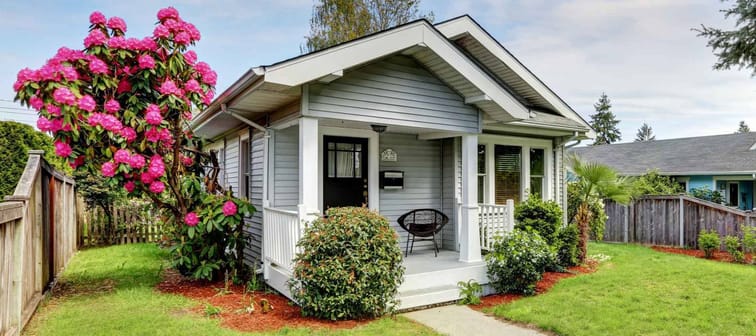 Cute craftsman home exterior with green grass and blooming tree. Northwest, USA
