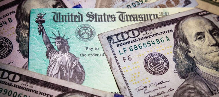 WASHINGTON DC - APRIL 2, 2020: United States Treasury check with US currency. Illustrates IRS coronavirus stimulus check.