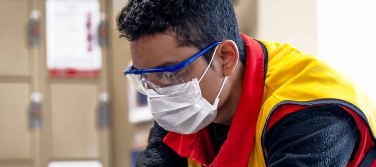 Lima, Peru - May 26 2020: Plaza vea supermarket worker wearing a mask and glasses amid coronavirus outbreak in South America.