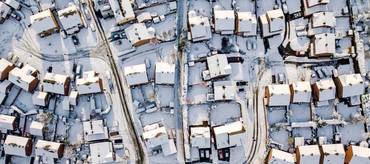 Aerial view of snowed in traditional housing suburbs in England. Snow, ice and adverse weather conditions bring things to a stand still.