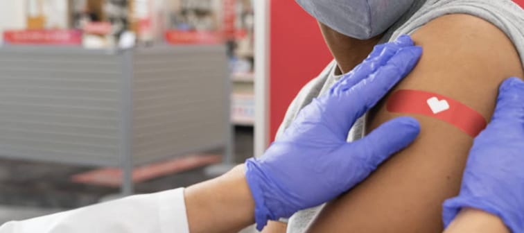 Pharmacist applying a band aid after flu shot