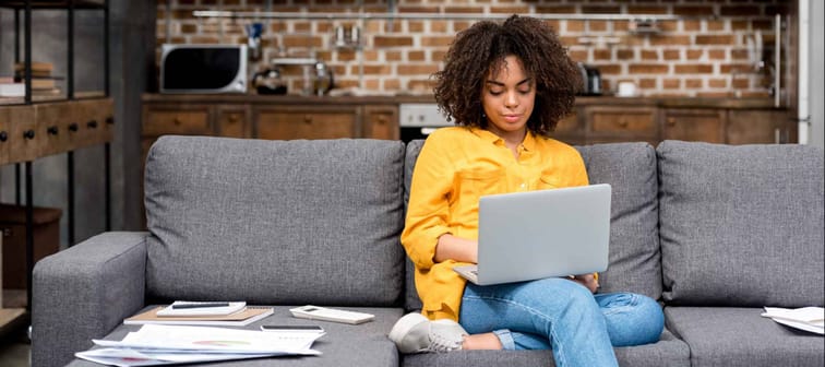 attractive young woman working working with laptop on couch
