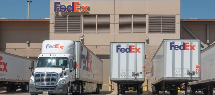 Semi-trucks delivery trucks pulled up to a FedEx warehouse at the Phoenix Sky Harbor Airport