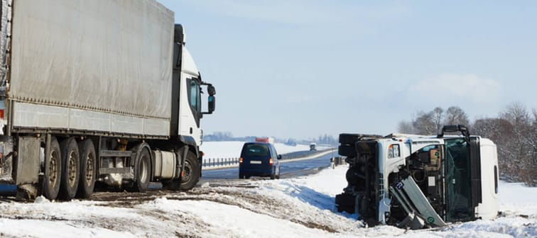 Truck and car crash on a snowy interstate highway.
