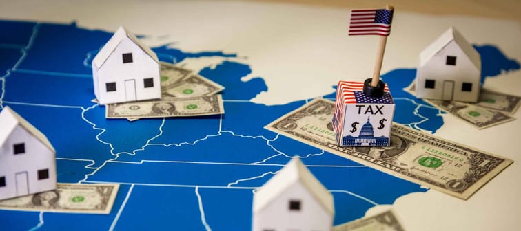 Family houses with dollar bills and central goverment tax over a US map.USA finance and economy concept related to the Tax Cuts and Jobs Act. approved by the Senate in December