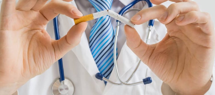 Doctor is breaking cigarette and giving advice to stop smoking.