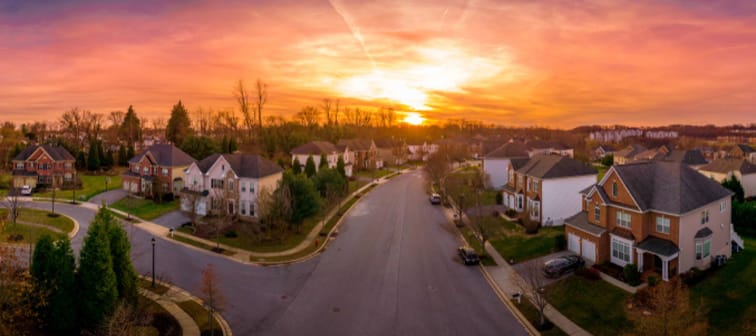 Aerial sunset panorama view of luxury upscale residential neighborhood gated community street in Maryland USA